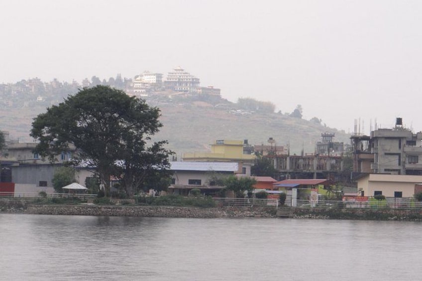 A river with buildings and a hill in the background. 2