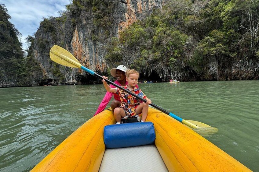 A person in a yellow kayak on a river with rocky cliffs in the background. 2