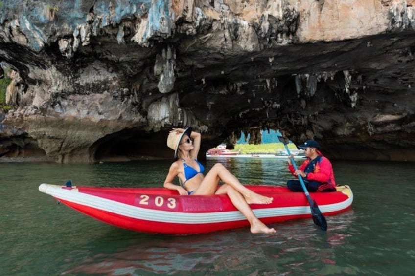 Un kayak rouge portant le numéro 203, une personne en maillot de bain bleu et une autre personne en veste rouge qui rame. 4
