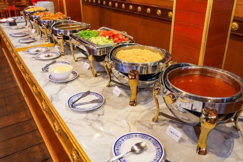 Un buffet proposant divers plats présentés dans des récipients en métal, disposés sur un comptoir en marbre. 5