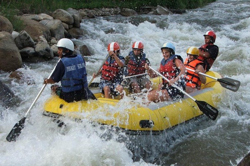 A group of people in a yellow raft navigating a river with rapids. 1