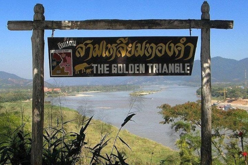 A signboard with 'The Golden Triangle' written on it, overlooking a river and hills. 2