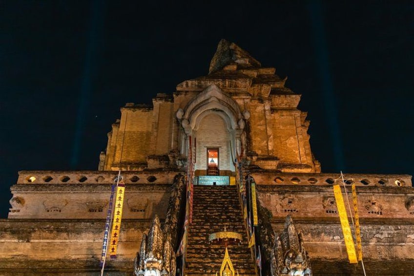 Vista nocturna de un templo con una escalera central que conduce a una entrada, iluminada por luces. 4