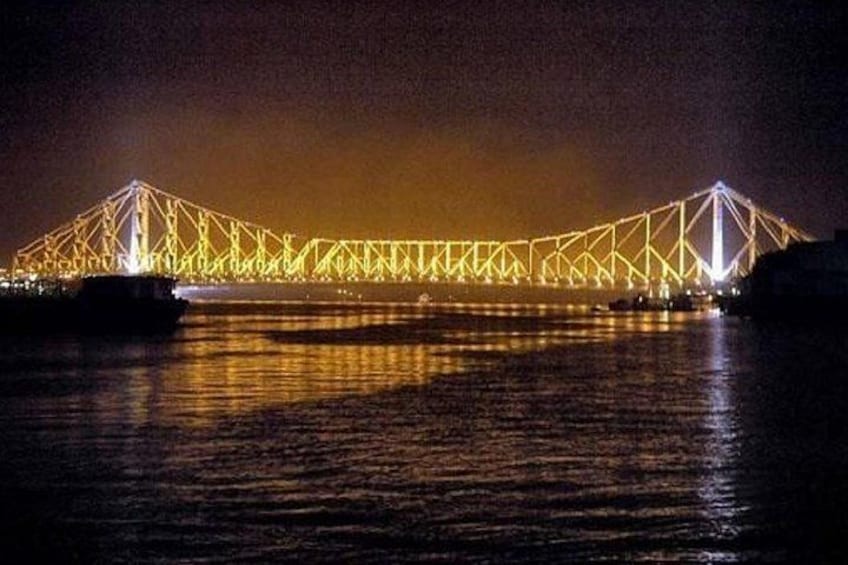 Eine beleuchtete Brücke bei Nacht, Spiegelungen im Wasser. 1