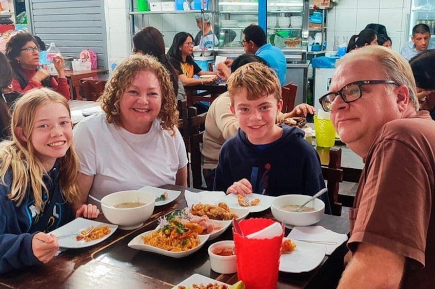 A family dining at a restaurant with various dishes on the table. 4