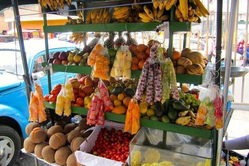 A fruit stand with bananas, oranges, and other fruits. 5