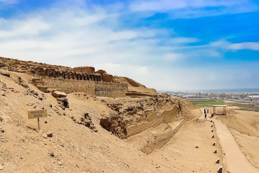 Een oude archeologische plek met een grote stenen constructie en een woestijnlandschap. 3