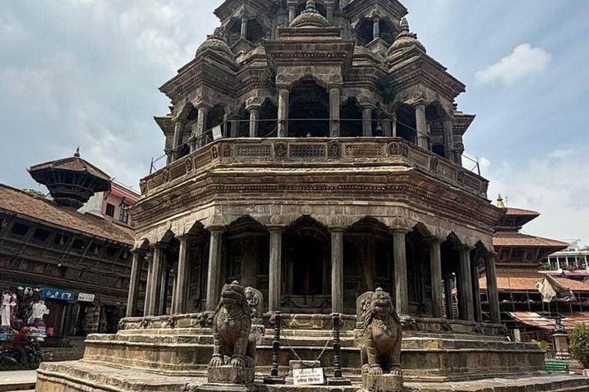 A historic temple with intricate carvings and two lion statues at its entrance. 2