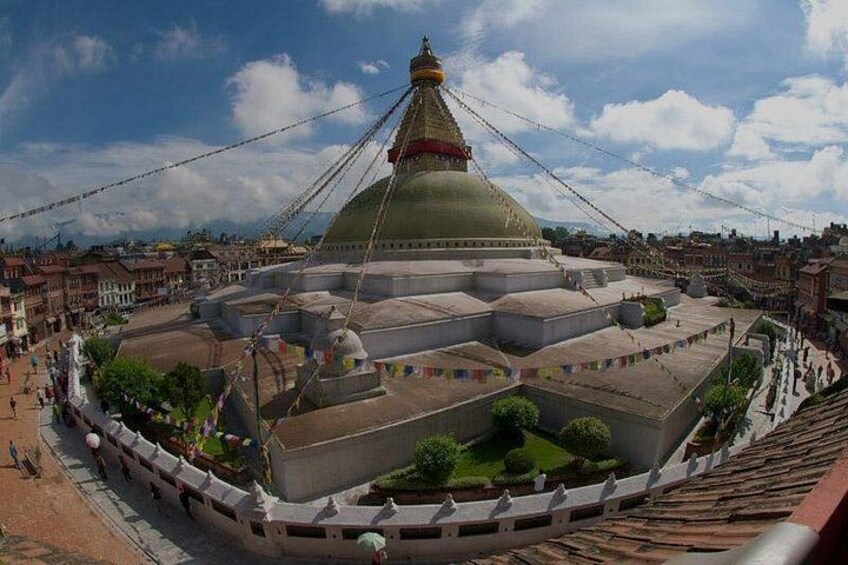A large domed building with a spire, surrounded by a low wall and a pathway. 1