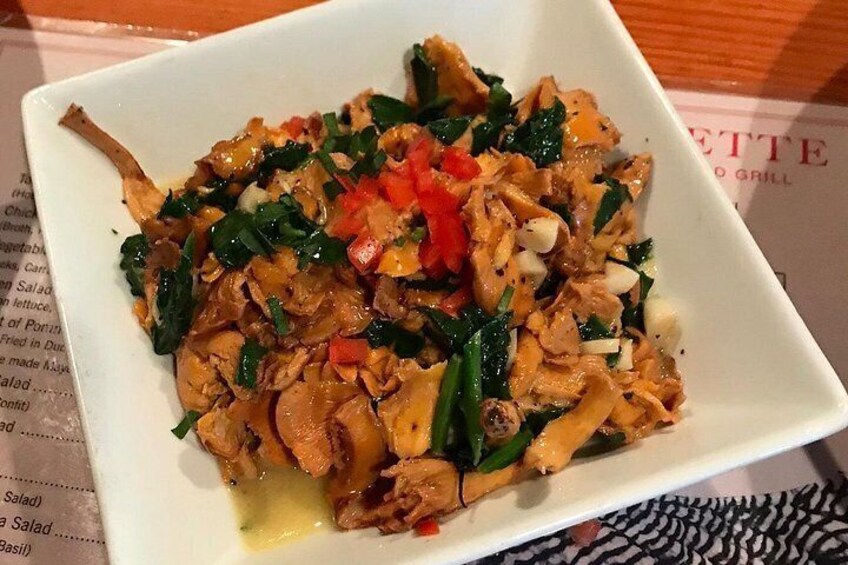 A white square plate with a stir-fry dish containing chicken, vegetables, and red peppers. 2