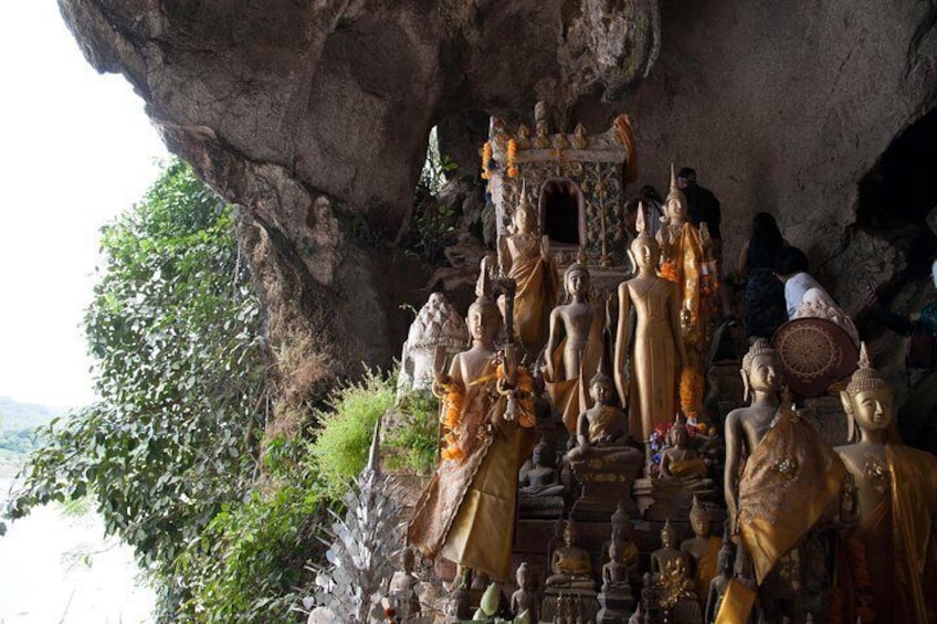 A rock formation with a Buddha statue and other religious figures. 2