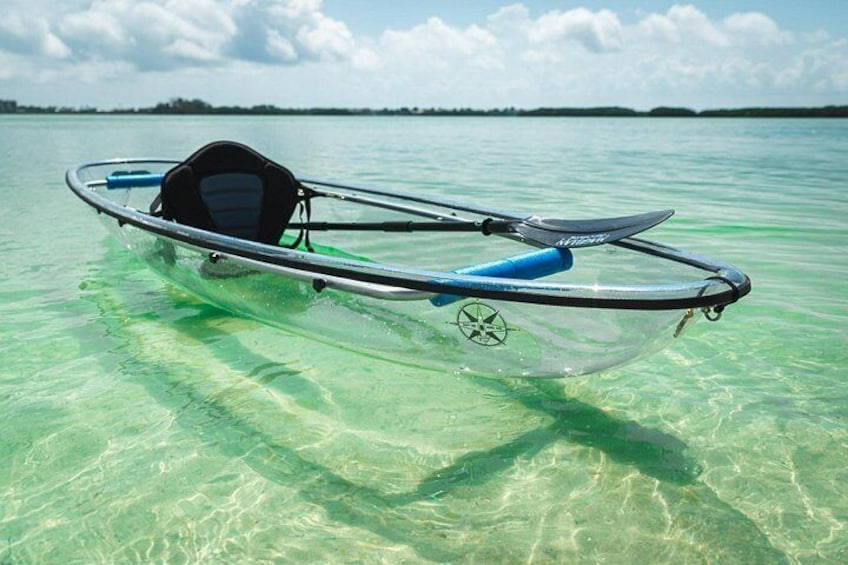 A clear blue water body with a transparent boat floating on it. 2