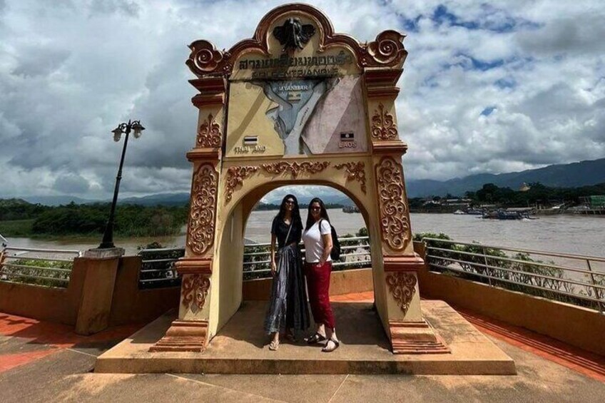 An ornate archway with inscriptions, a river in the background, and a cloudy sky. 1