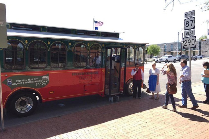 A vintage bus parked on a brick sidewalk with people standing nearby. 3