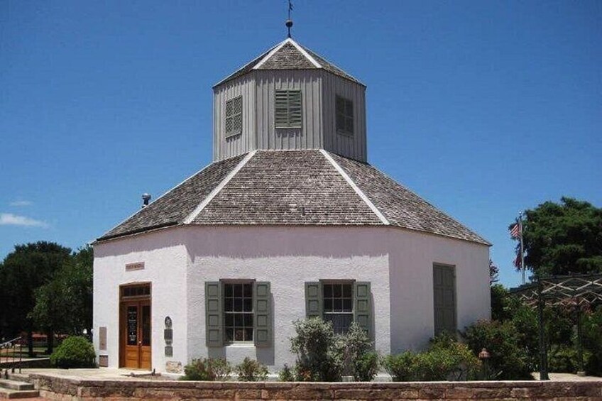 Une église blanche avec un clocher et une porte en bois. 2