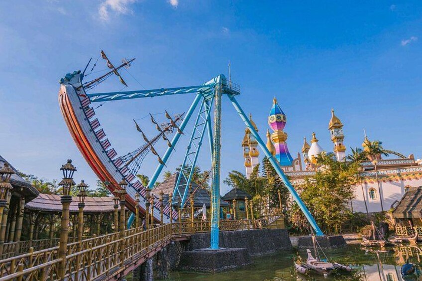 A roller coaster with a blue track, a colorful building with domes, and a bridge. 2