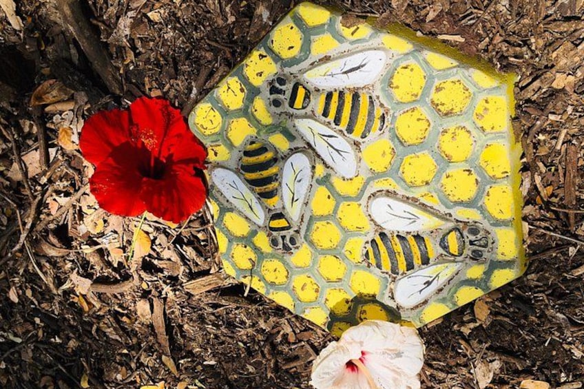 En röd blomma, ett föremål med gult och grönt mönster och en vit plastpåse på en mark som är täckt av löv. 4