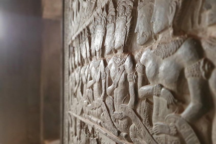 A detailed stone carving of a battle scene with warriors and elephants. 4
