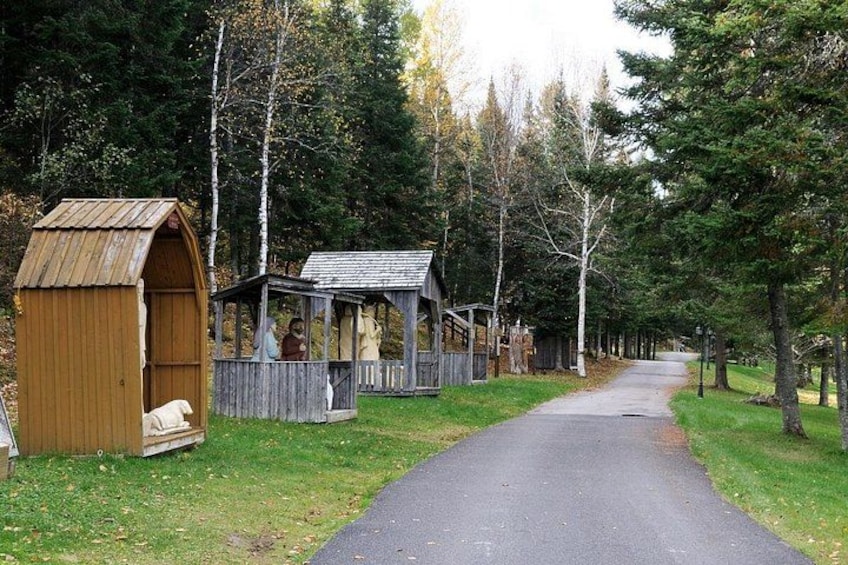 A rural pathway flanked by wooden structures and trees. 2