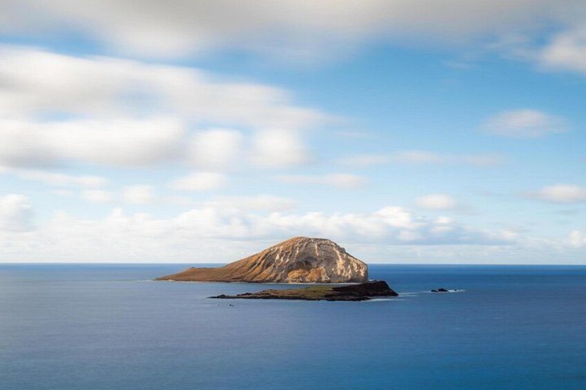Un paisaje costero con una isla rocosa destacada, rodeada de aguas azules tranquilas. 5