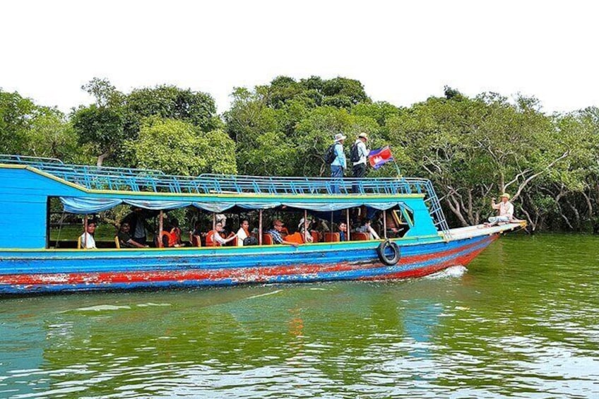 A boat with passengers, surrounded by water and trees. 5