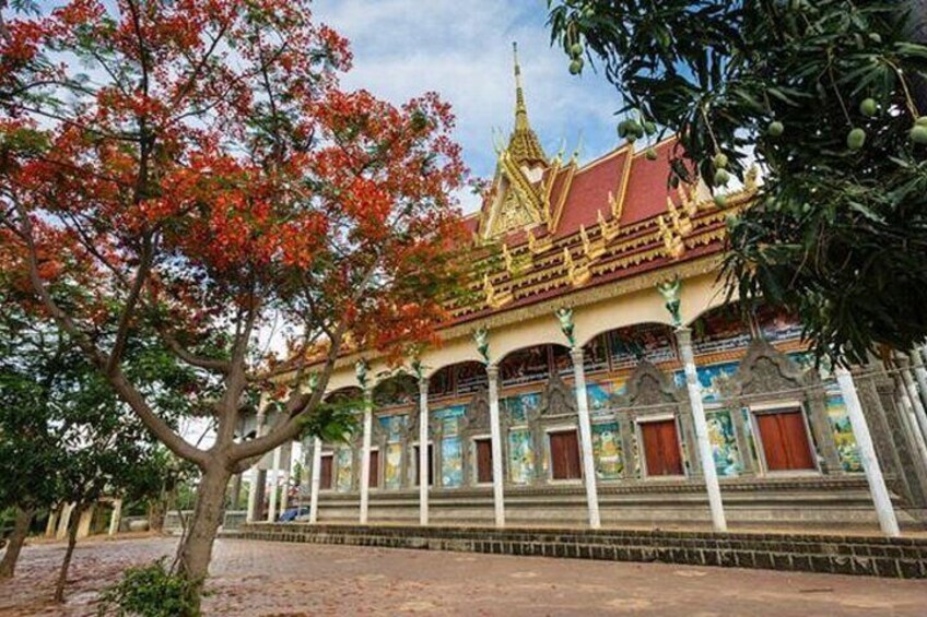 A traditional temple with ornate architecture, a tiered roof, and a large tree in the foreground. 4