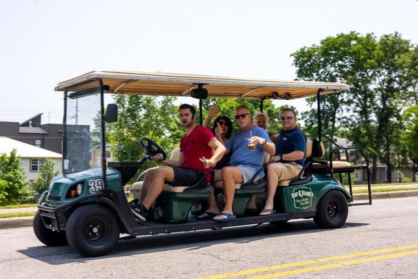 A golf cart with four people on a street. 3