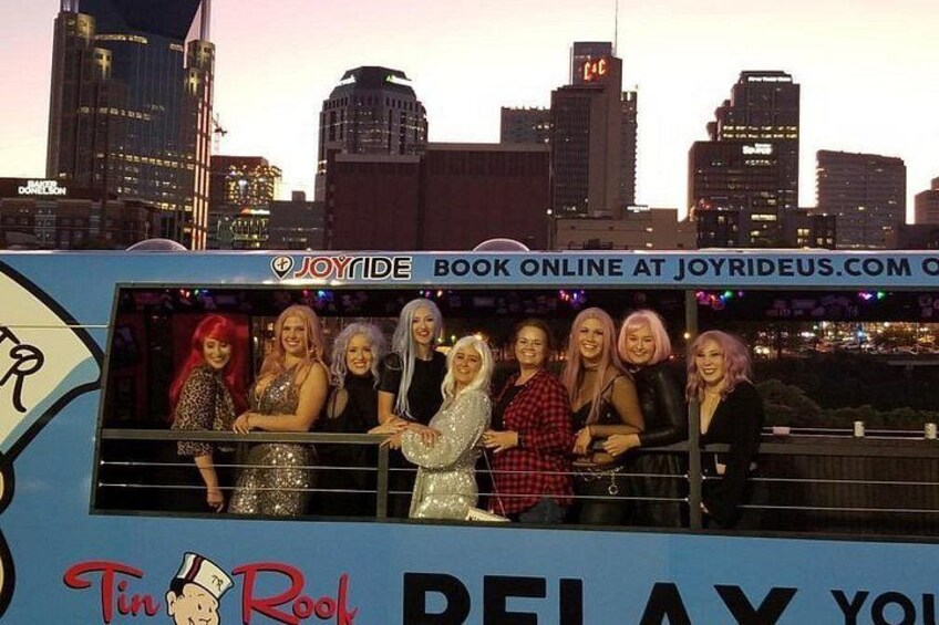 A group of people on a bus with a city skyline in the background. 5