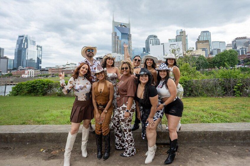 A group of people posing in front of a city skyline with modern buildings. 2
