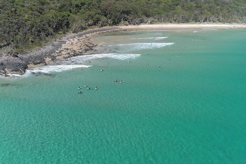 Una zona costera con aguas turquesas cristalinas, una playa de arena y un litoral rocoso. 4