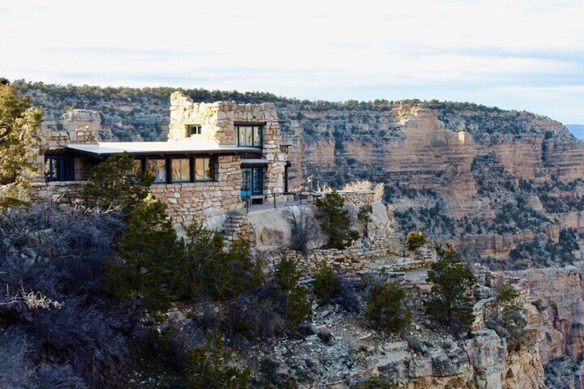 A stone house on a cliff overlooking a canyon. 3
