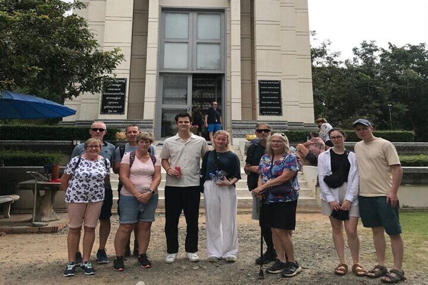 A group of people standing in front of a building with a large window and a plaque. 5