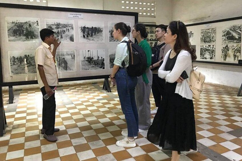 Un gruppo di persone in un museo con fotografie storiche esposte. 1