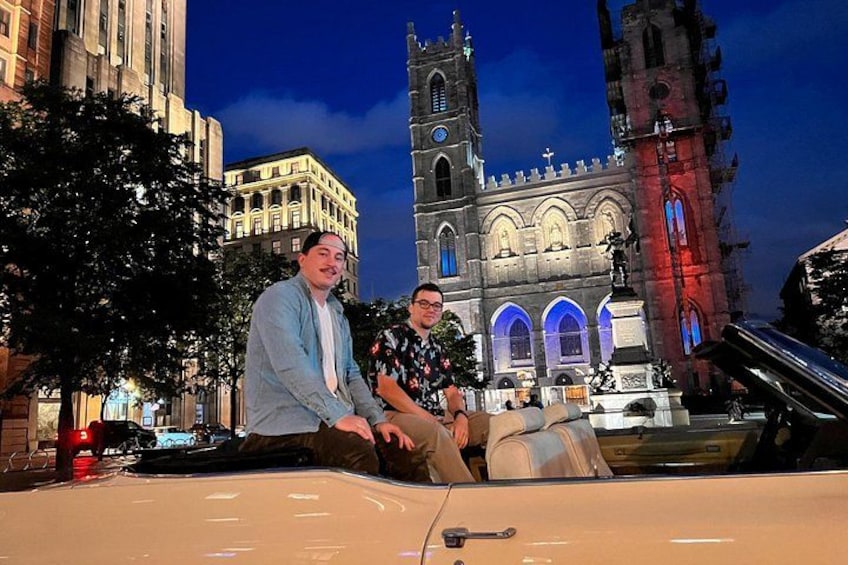 Two people sitting in a car with a historic church in the background. 5