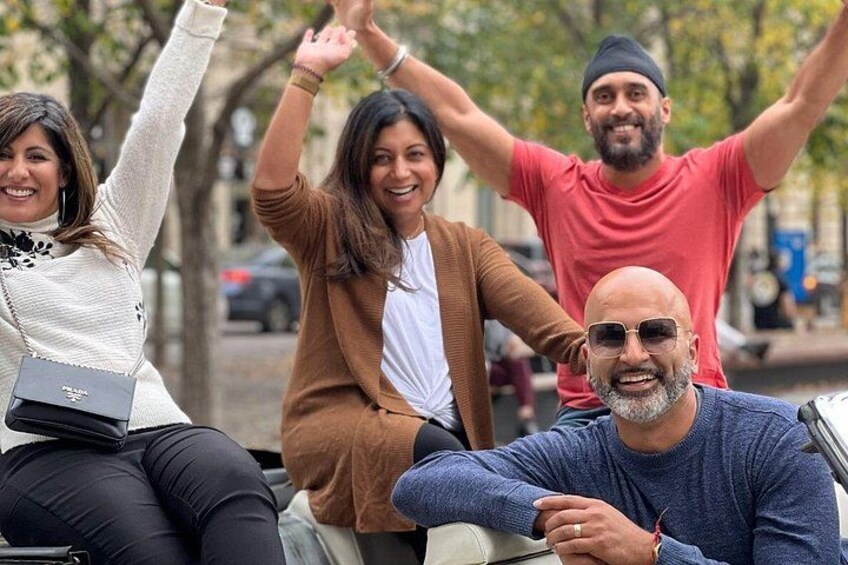 A group of people sitting on a bench outdoors. 2