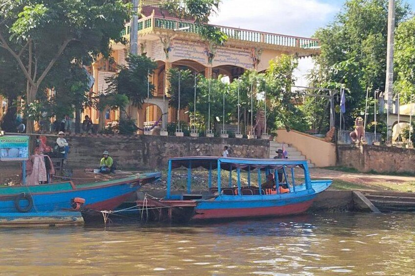 A river with boats, a bridge, and a building with a sign. 2