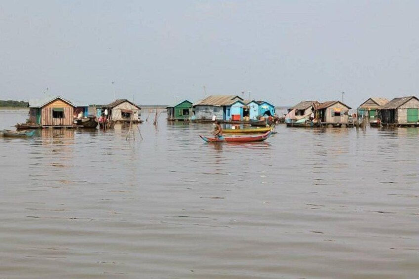 A river with floating houses and a boat. 5
