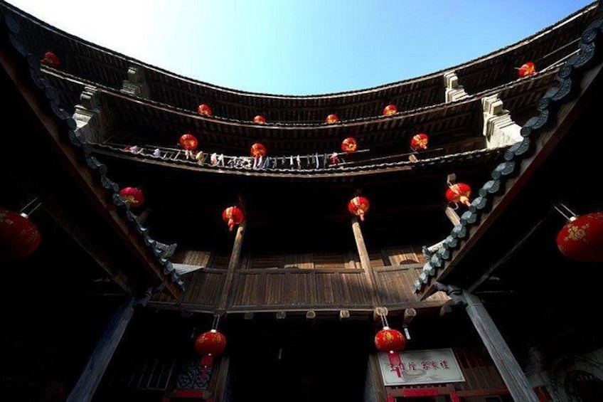 A traditional Chinese building with curved wooden architecture, red lanterns, and a clear blue sky. 3