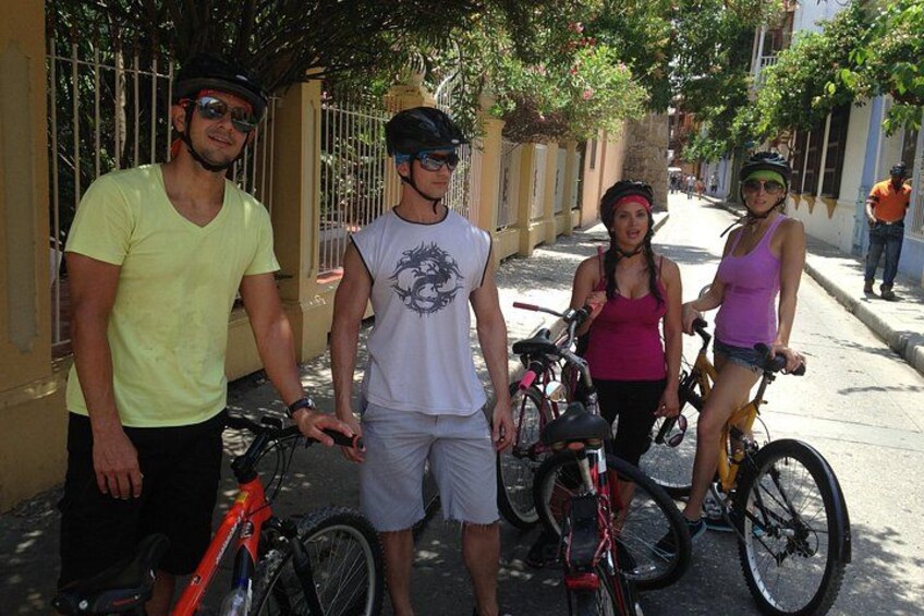 A group of people standing on a street with bicycles. 2