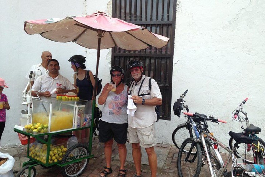 A street vendor's cart with fruits, a bicycle, and a building in the background. 5