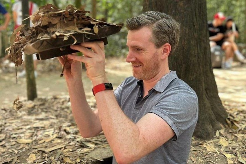 A person holding a large, flat object covered in leaves. 1
