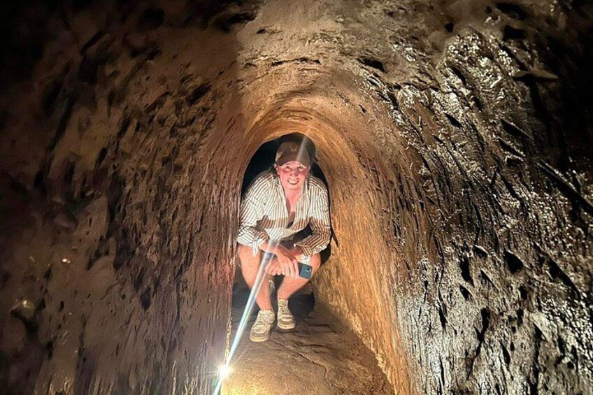 Una persona agachada dentro de un túnel estrecho y rocoso. 2