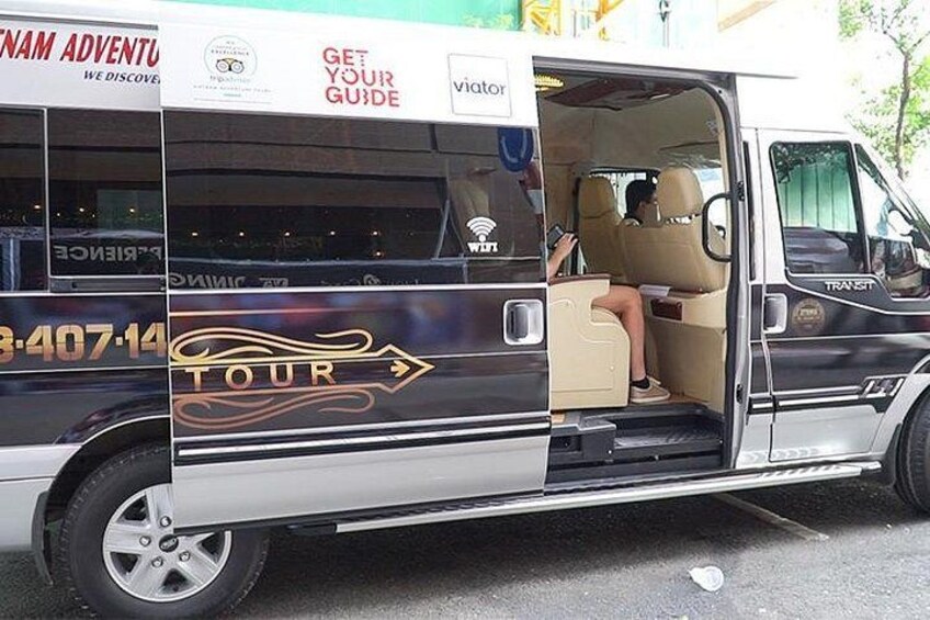 A tour bus with 'TOUR' and 'GET YOUR GUIDE' text, a contact number, and a Wi-Fi symbol. 5