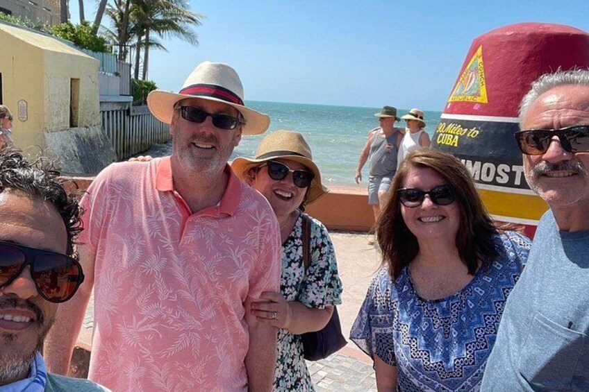 Un gruppo di persone in piedi su una spiaggia, con una barca sullo sfondo. 3