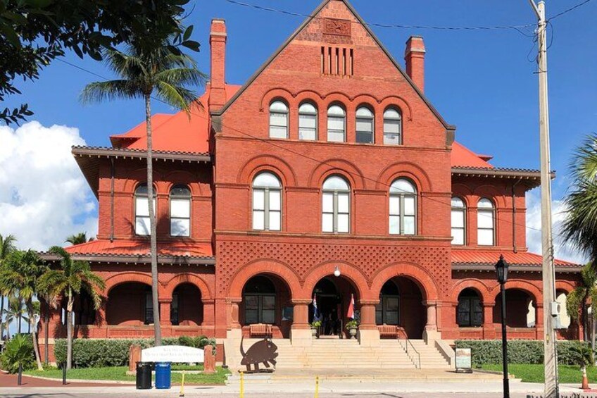 A large red brick building with arched windows and a central entrance. 2