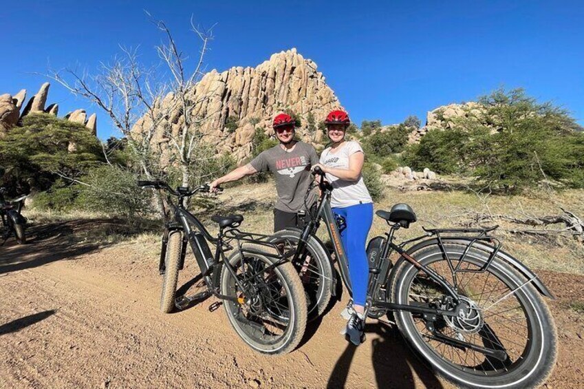 Dos personas con bicicletas en un paisaje desértico con formaciones rocosas. 4