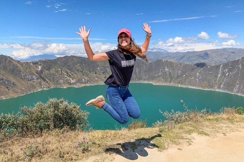 A person jumping in mid-air with a mountainous landscape and a lake in the background. 4