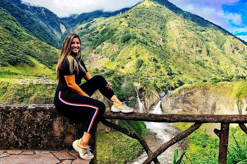 Una persona sentada en un muro de piedra mirando un río con montañas al fondo. 2
