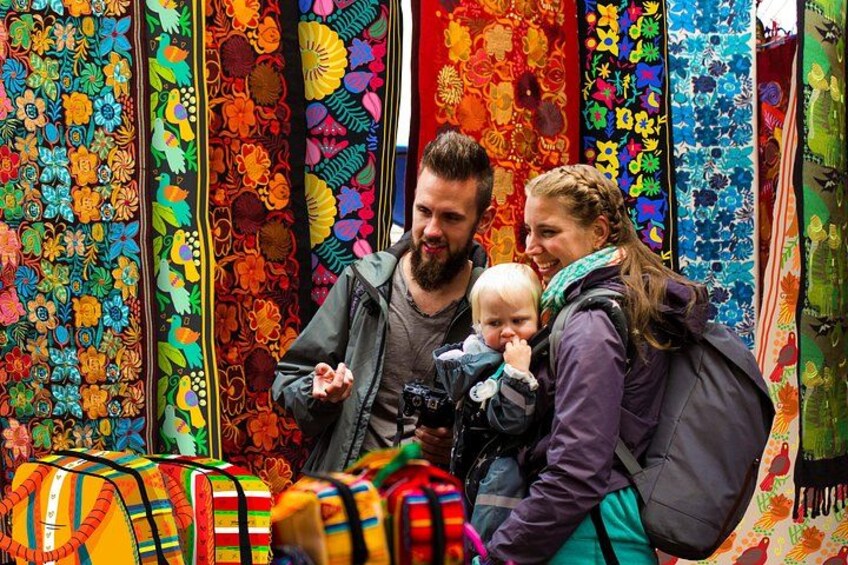 A family browsing colorful textiles at a market. 2