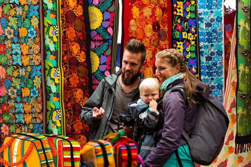 A family browsing colorful textiles at a market. 2